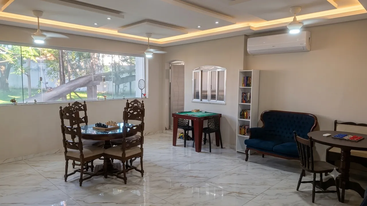 Sala de convivência ampla com mesas de jogos, sofá e estante de livros